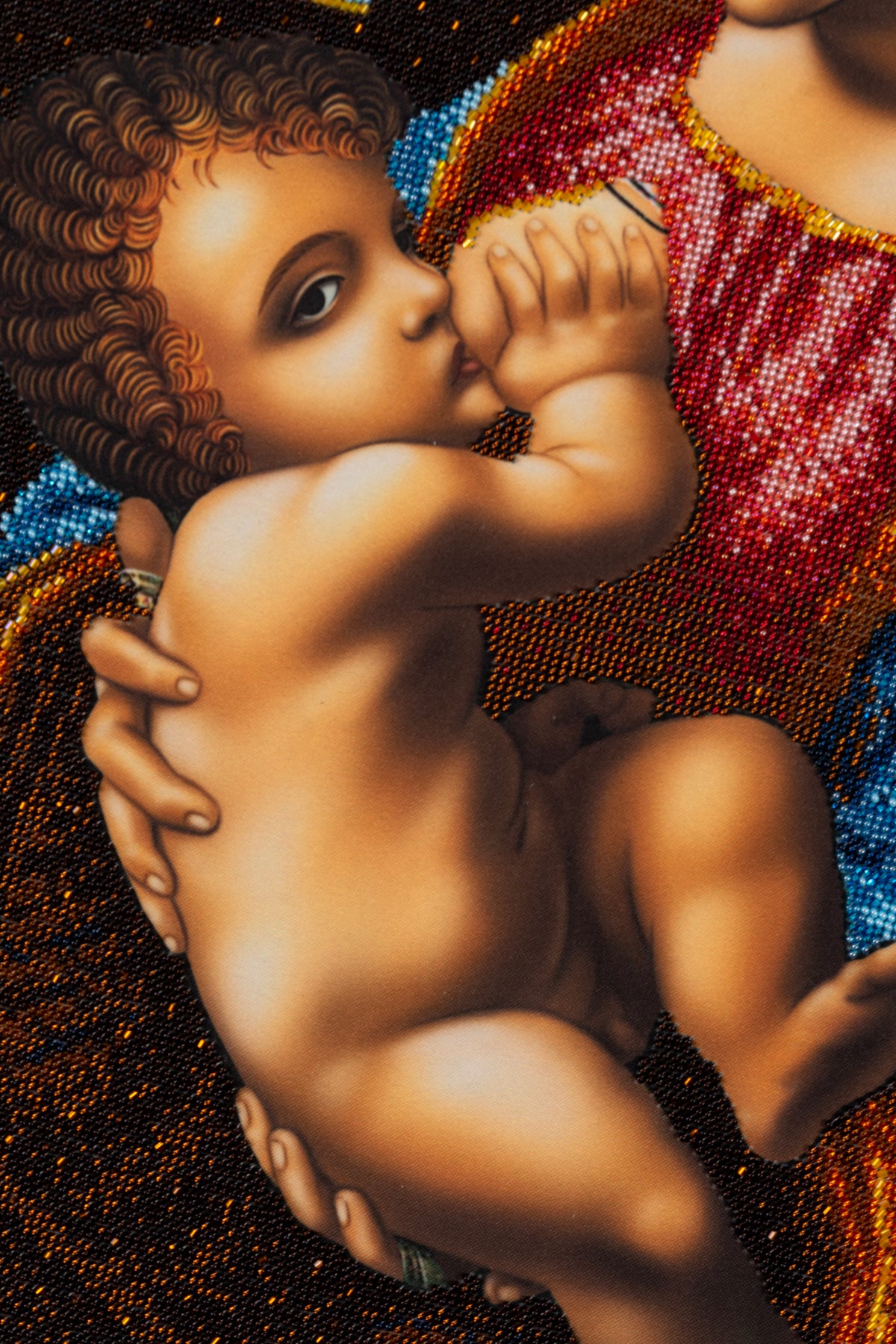 Close-up of the Child in Madonna bead embroidery artwork, showing the detailed transition between printed fabric and beadwork