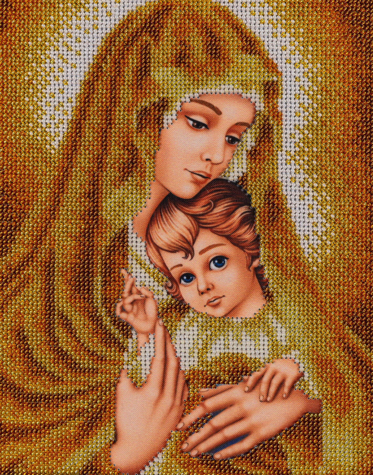 Close-up of Gold Madonna showing the Virgin Mary holding the Christ Child, surrounded by shimmering golden and ivory glass beads.