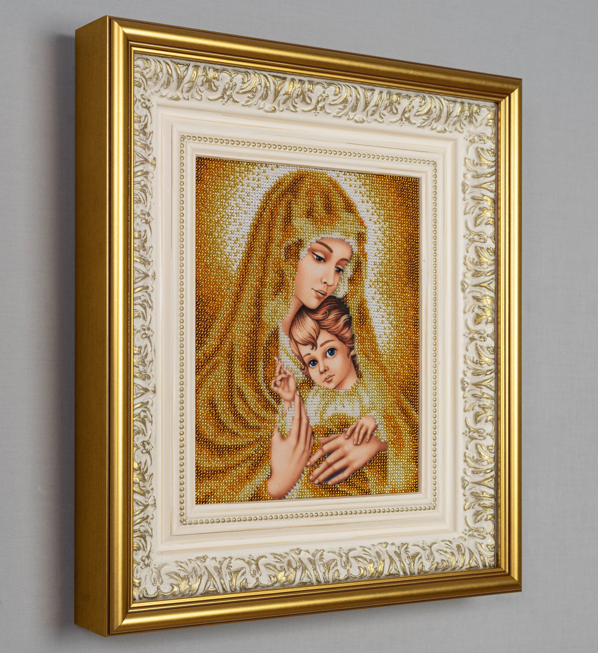 Angled view of the framed Gold Madonna artwork showing the depth of the ornate gold and ivory frame.