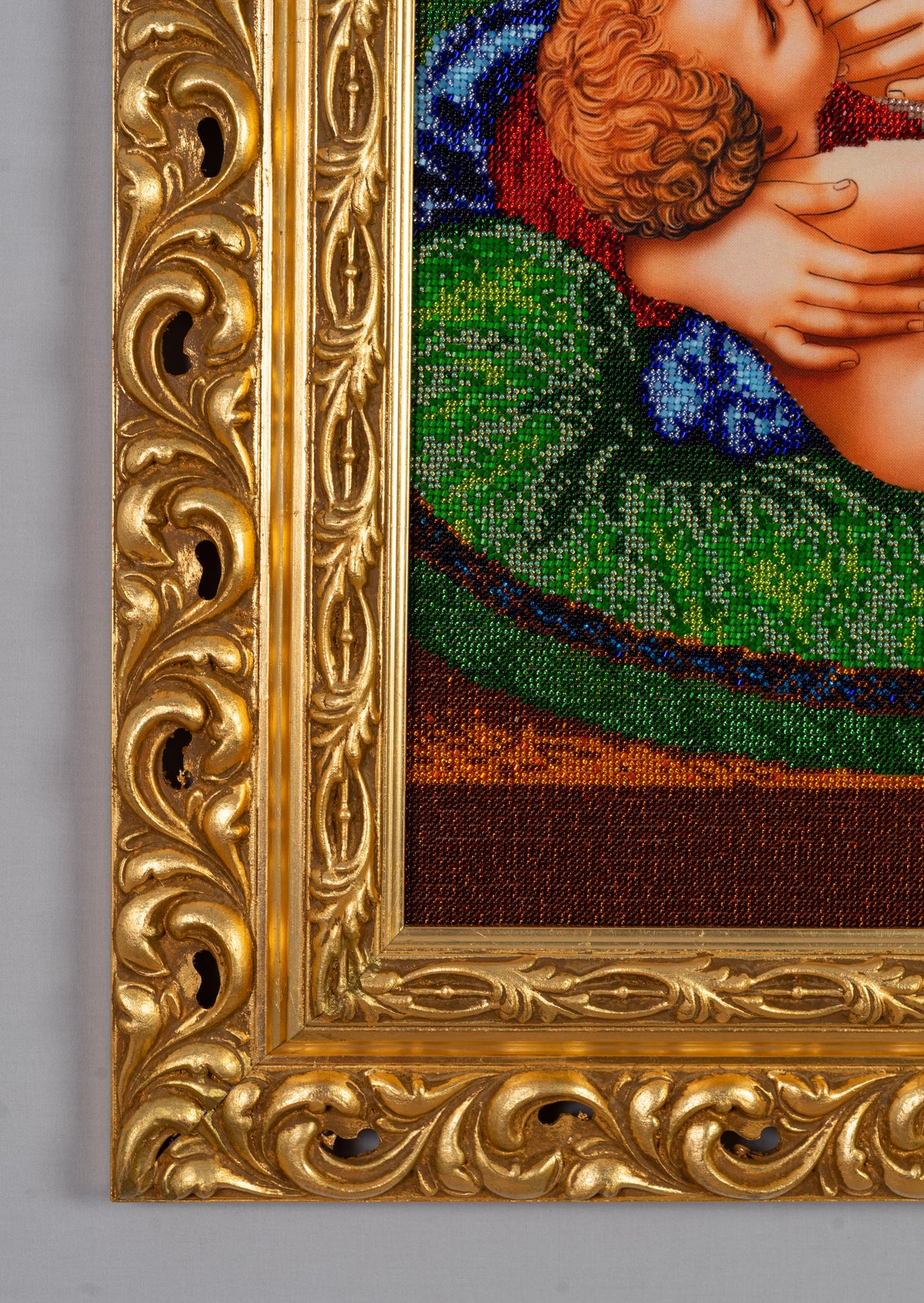 Detail of the ornate gold-leaf wooden frame of Madonna and Child in the Garden
