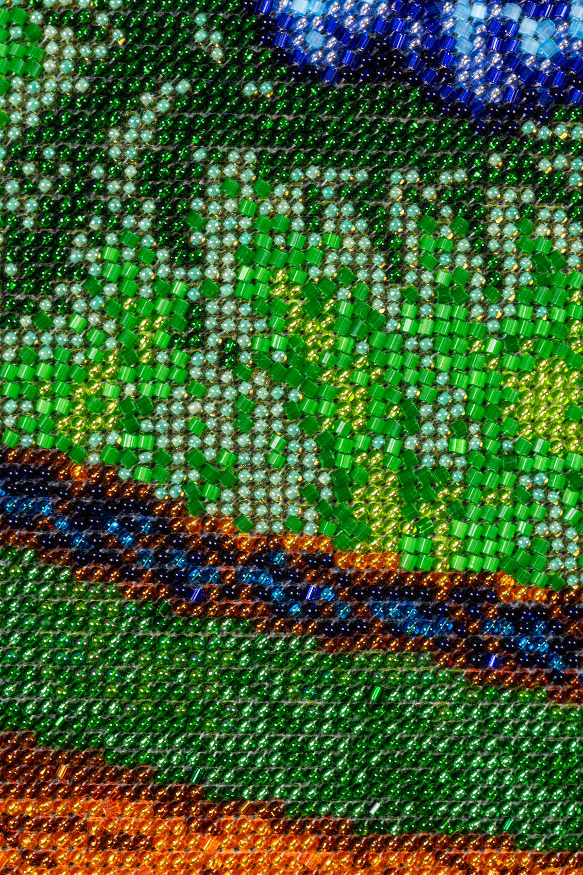 Macro detail of green Czech and Japanese glass beads in the hand-embroidered artwork