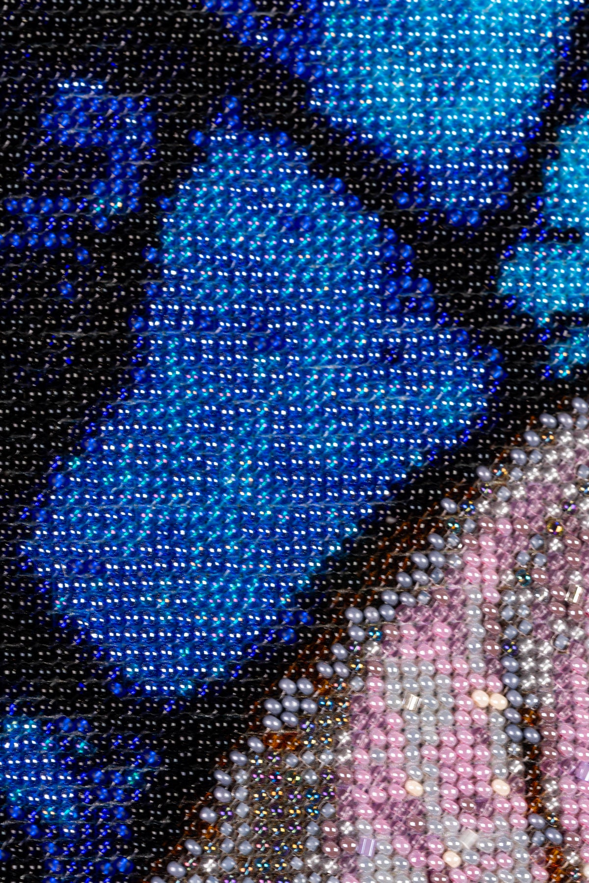 Macro detail of the blue background and St. Joseph’s robe, showing dense hand embroidery with shimmering Czech seed beads