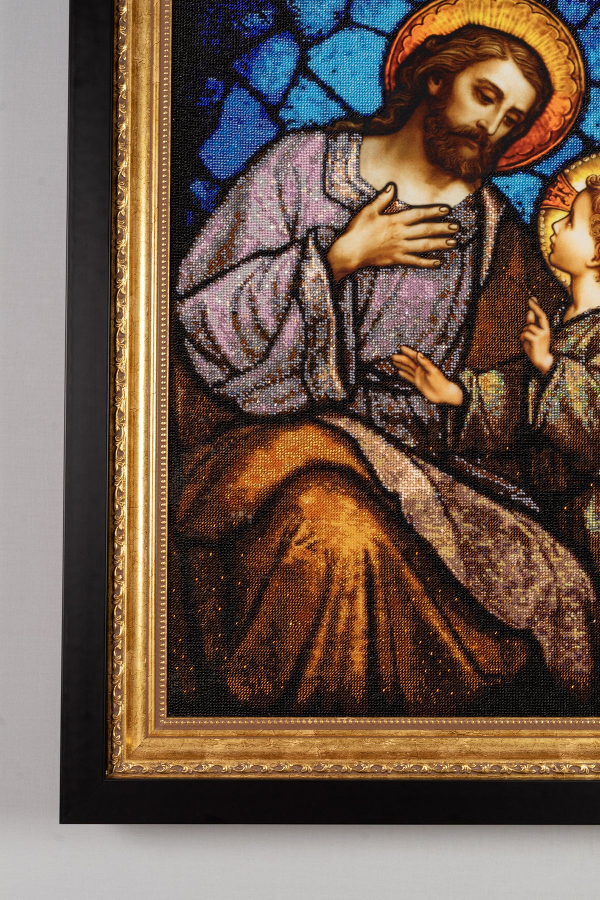 Close-up of the gold wooden frame and black outer kiot surrounding the hand-beaded St. Joseph & Jesus artwork