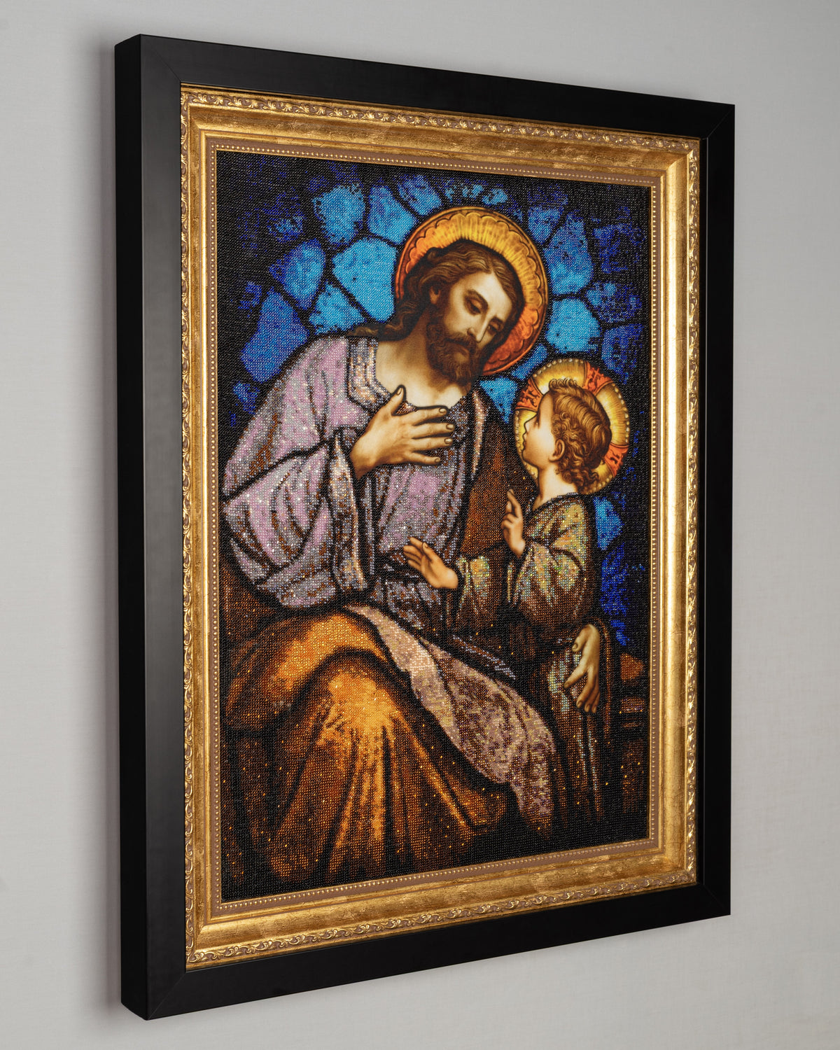 Side view of framed St. Joseph & Jesus bead embroidery artwork showing the depth of the black outer kiot and gold inner frame