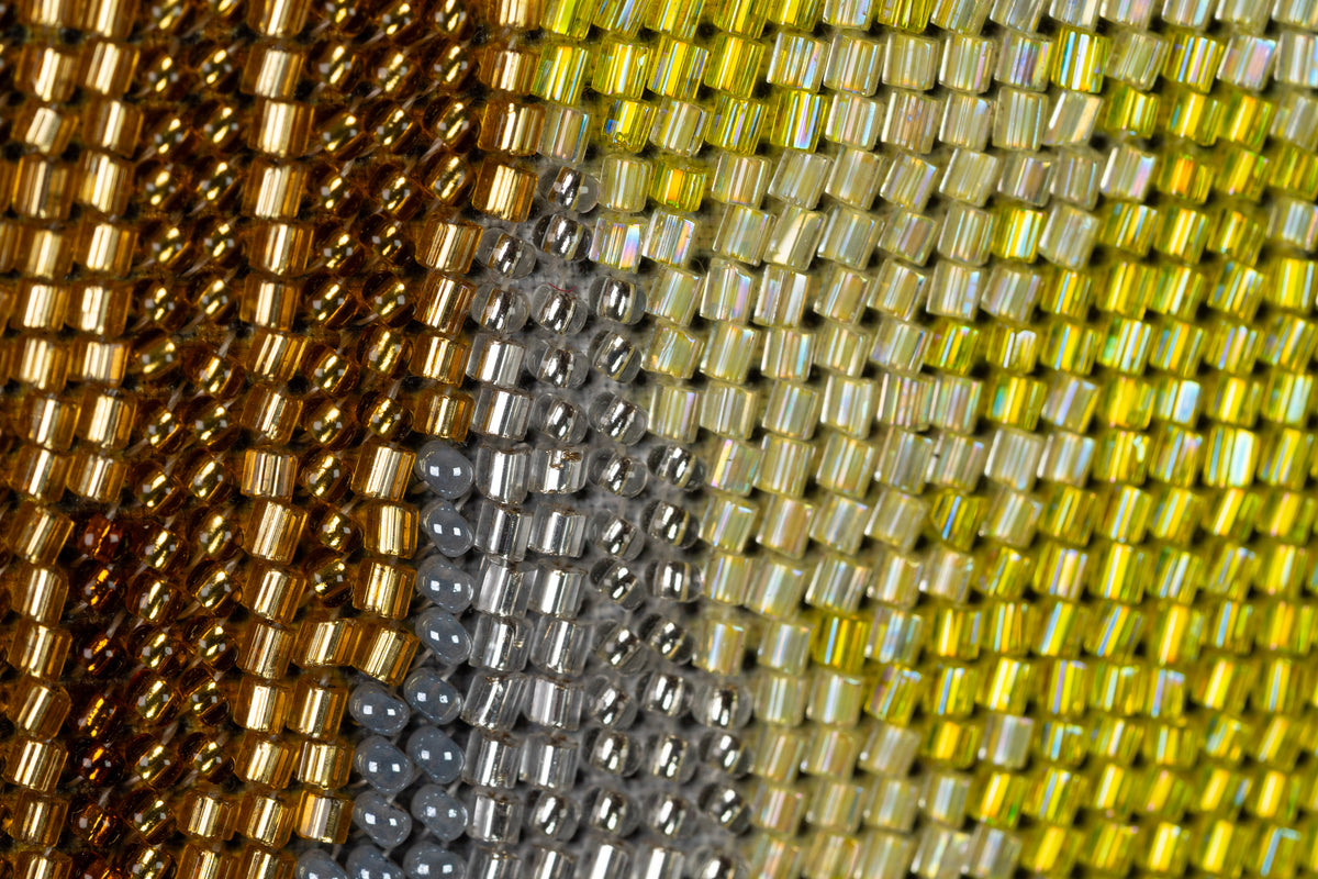 Extreme macro of the beadwork in Incarnation showing cylindrical and round beads with reflective finishes