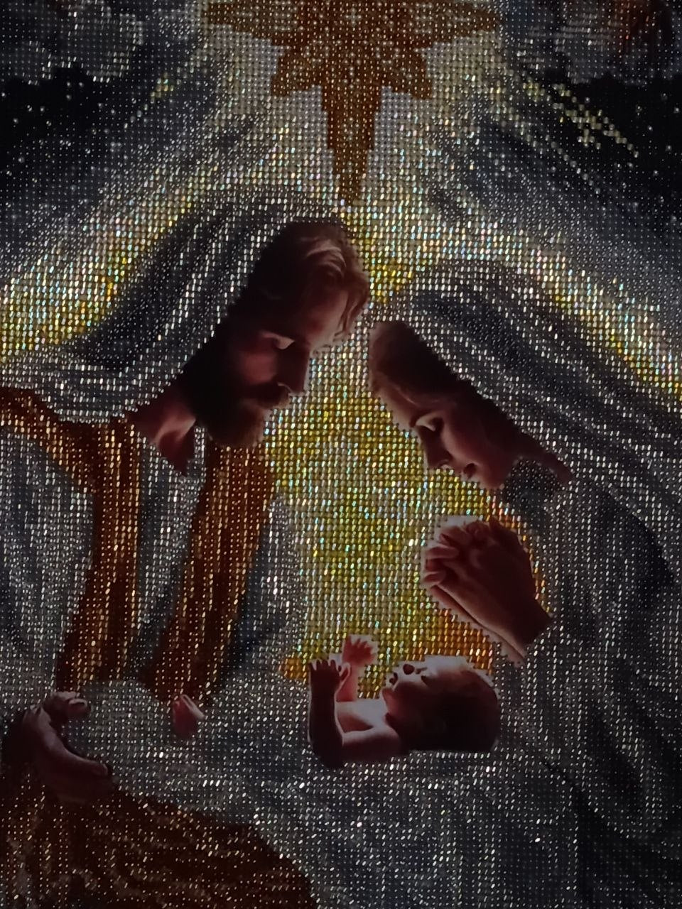Incarnation photographed in low light, revealing the reflective shimmer of the bead embroidery around the Nativity figures