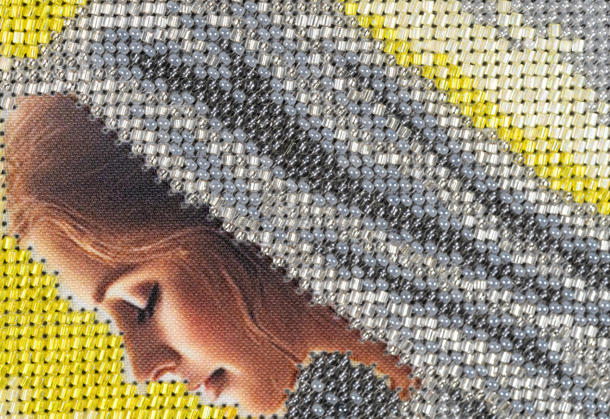 Macro detail of Mary and Joseph in Incarnation showing the texture and density of the bead embroidery