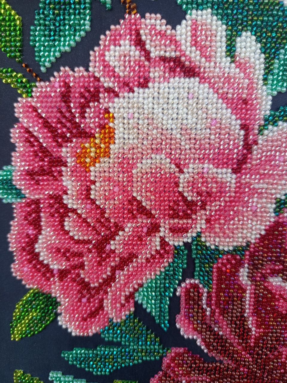 Macro detail of a pink peony showing the colour transitions and individual glass beads of the embroidery